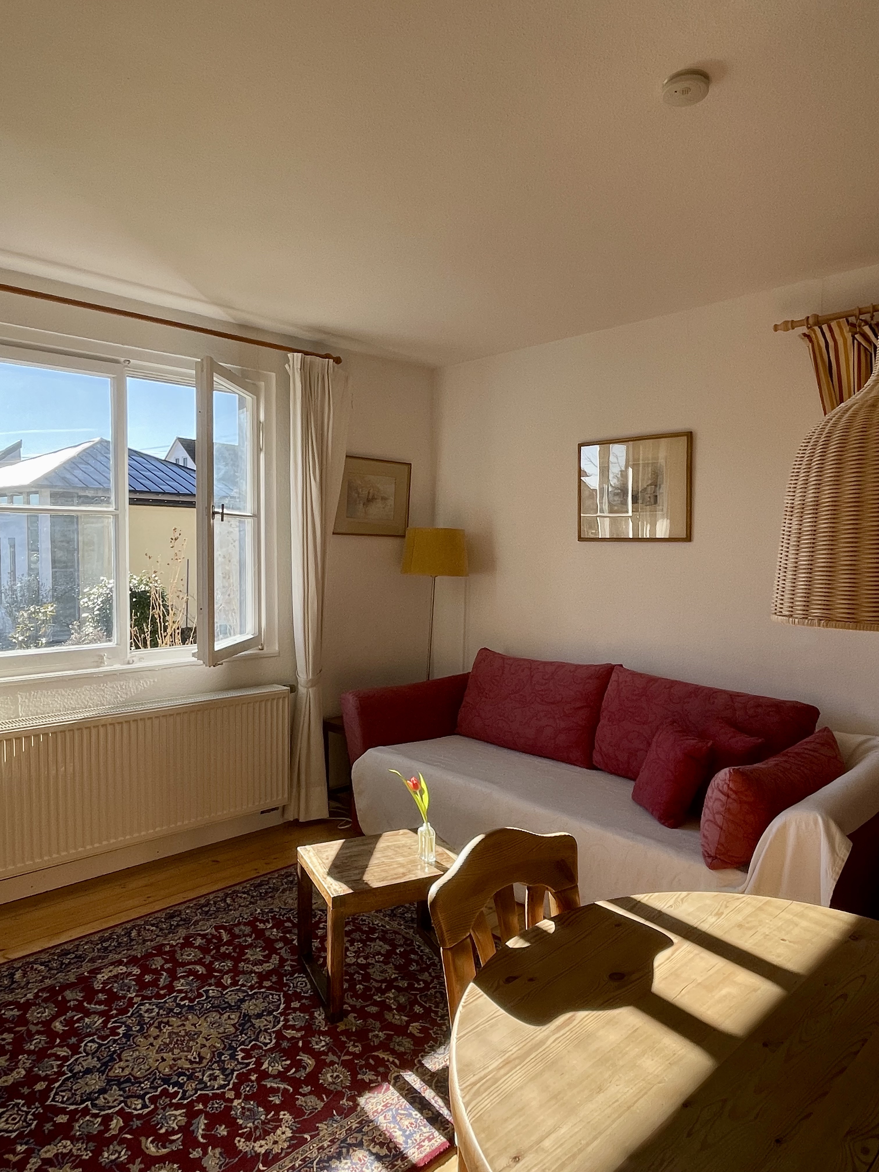 Bright sitting area at Villa Salem with sofa, rug and large open window