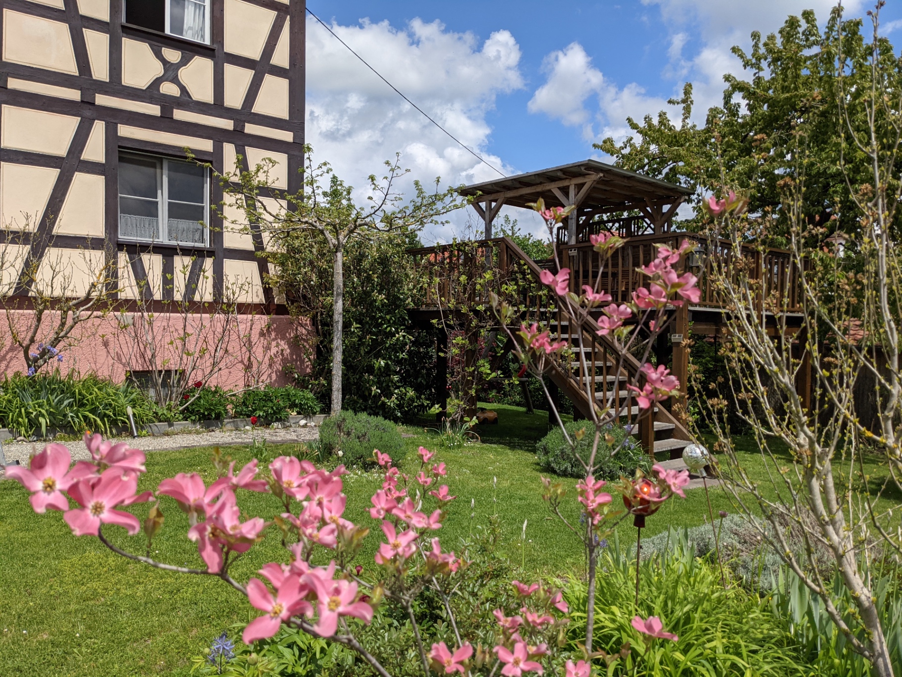Half-timbered facade of Villa Salem with spring blossoms and the wooden garden deck