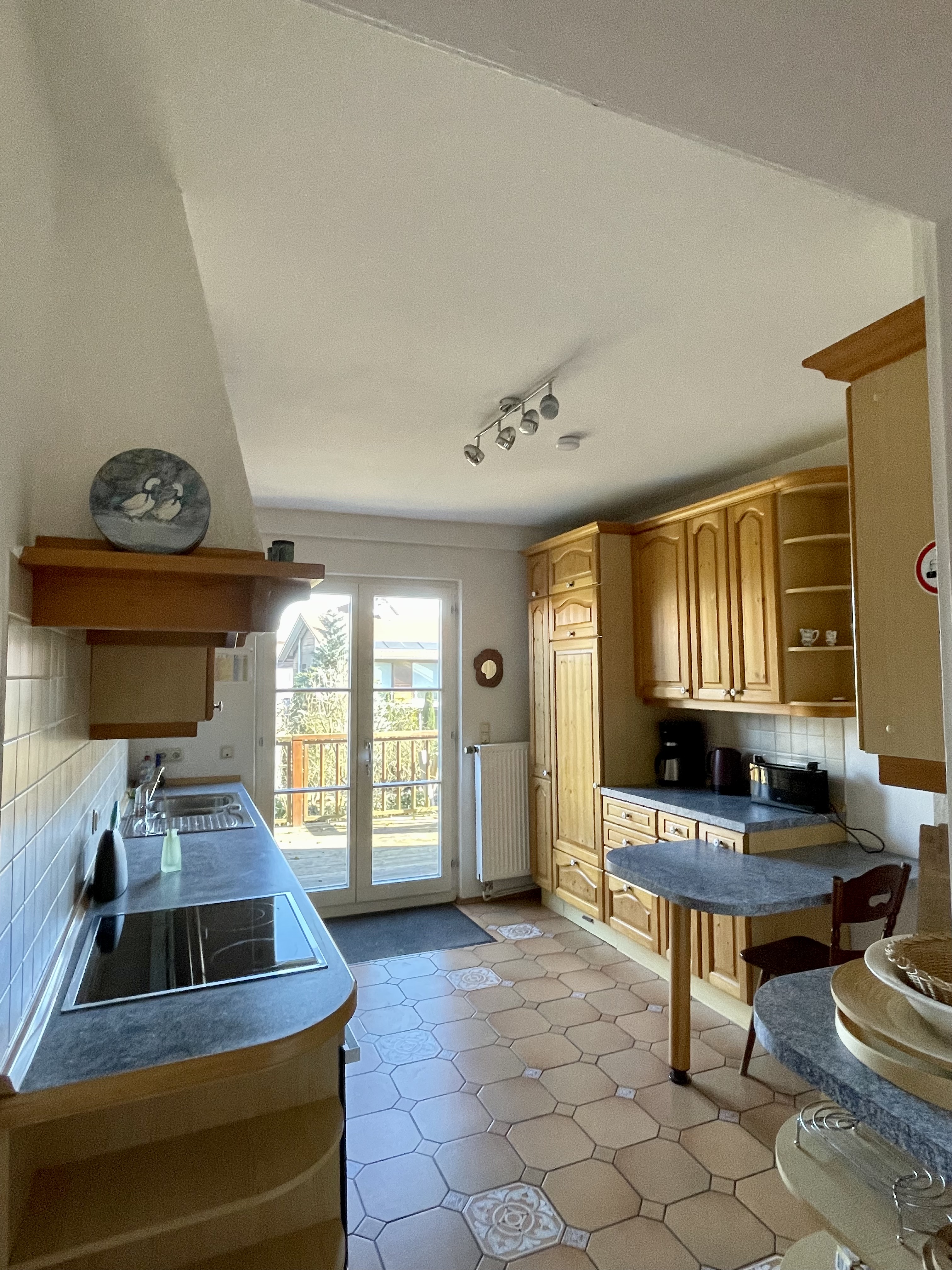 Family kitchen with wooden cabinets and balcony doors