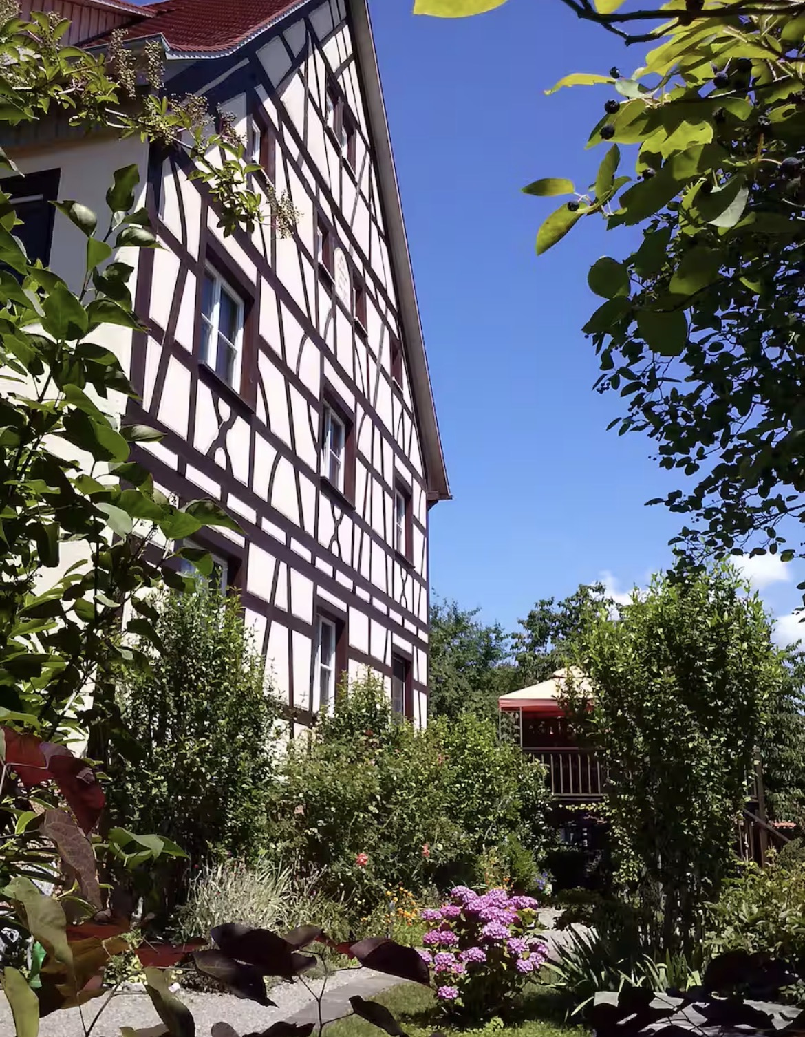 Half-timbered facade of Villa Salem with hydrangeas and lush garden